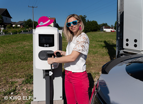 Frau vor Ladestation