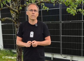 Mann vor einer PV-Anlage