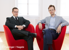 2 Männer auf roten Sesseln