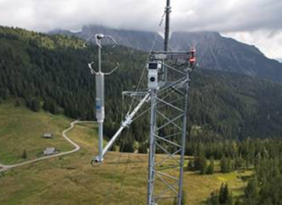 Messmast mit meteorologischen Sensoren in alpiner Landschaft
